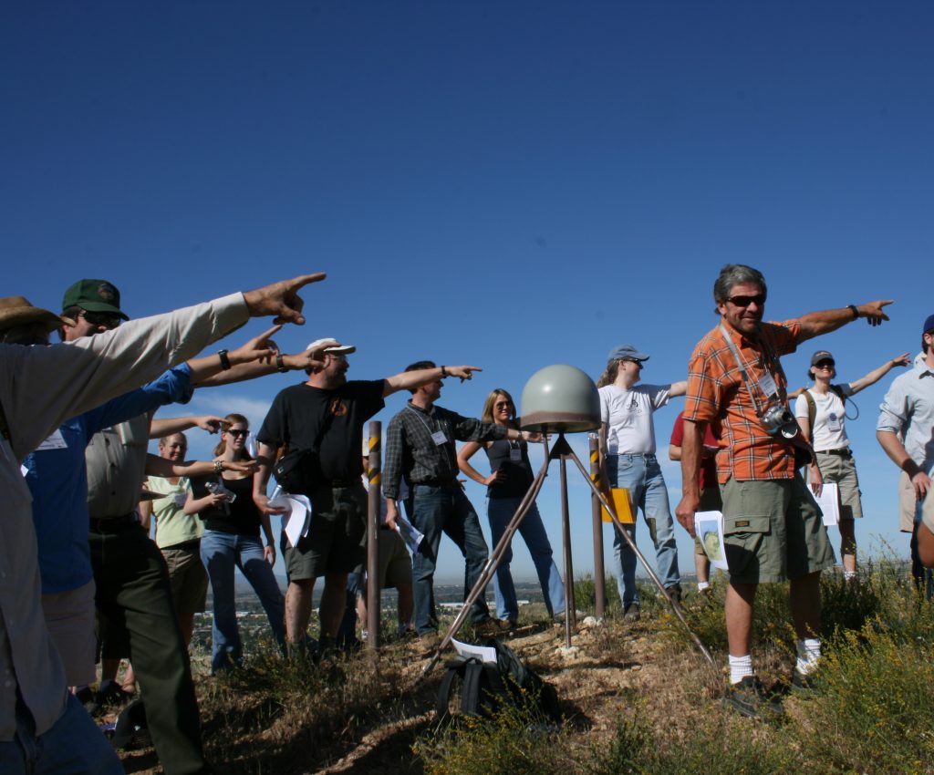 group pointing as they learn about a GPS station