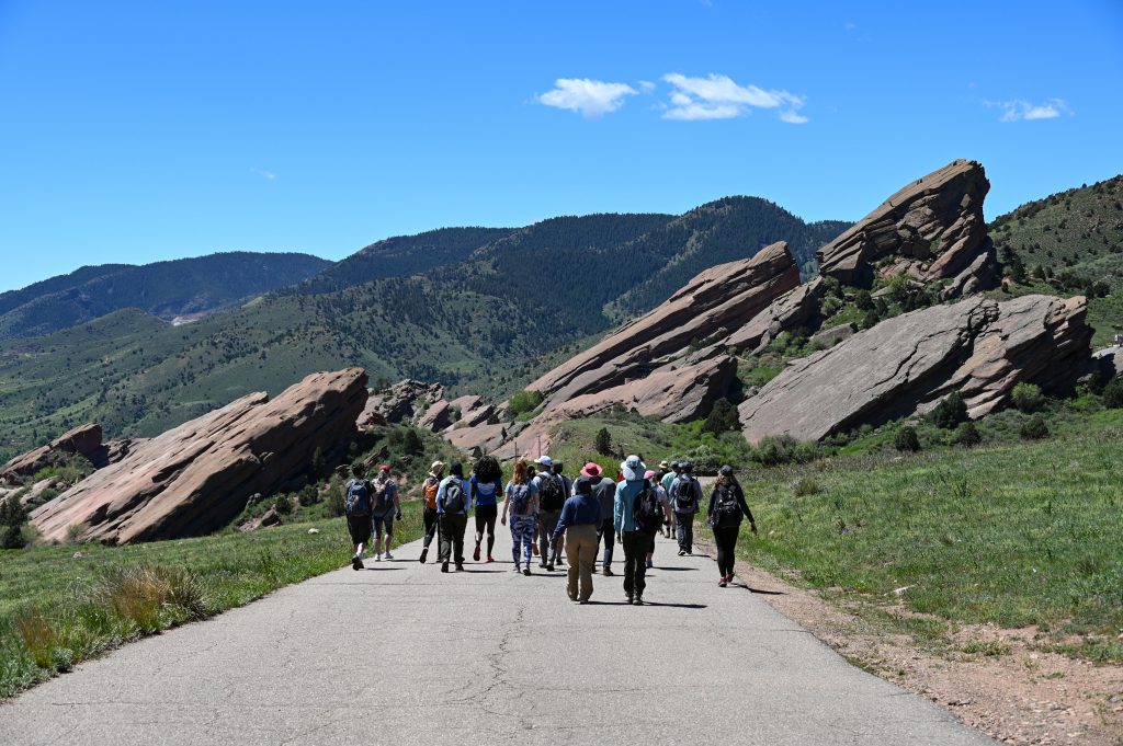 group walking down road with rocks in background