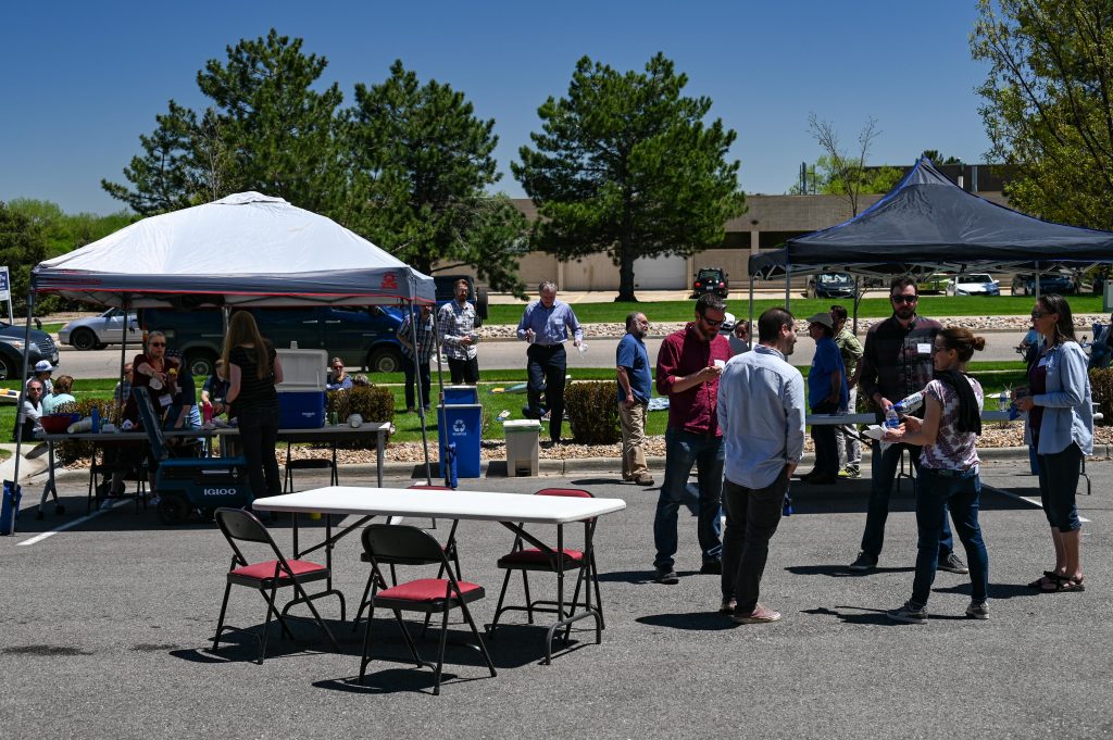 people talking outside around pop-up tents