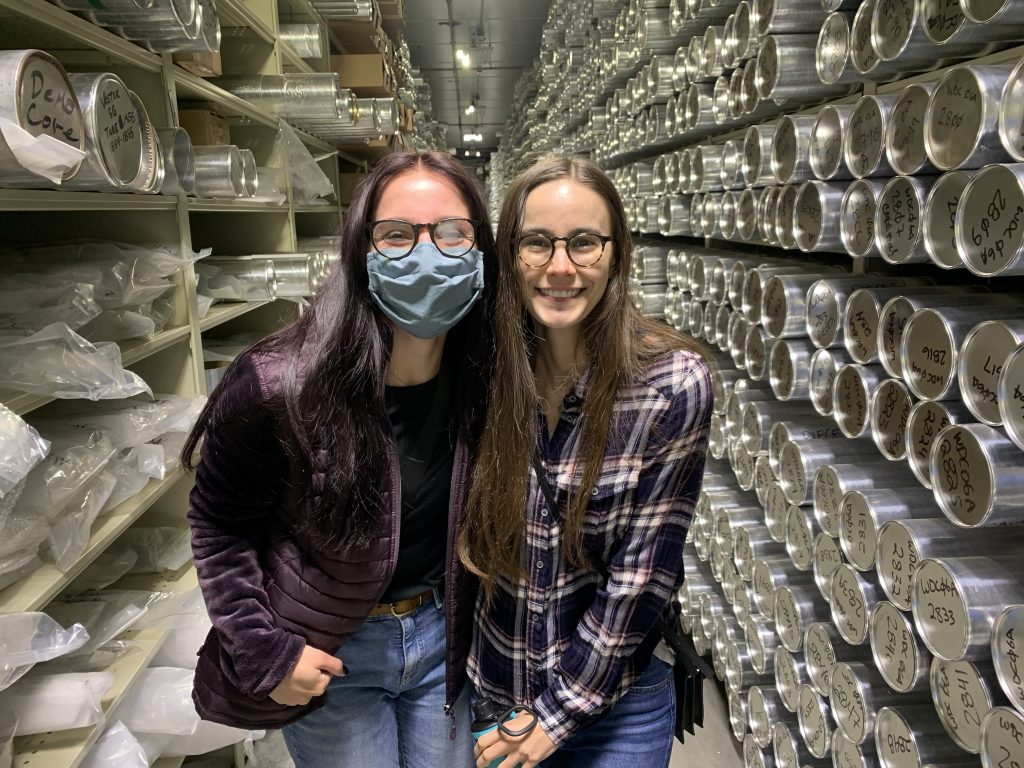 Geo-Launchpad interns Madalyn Massey and Allison Sowers smiling in front of rows of ice cores.