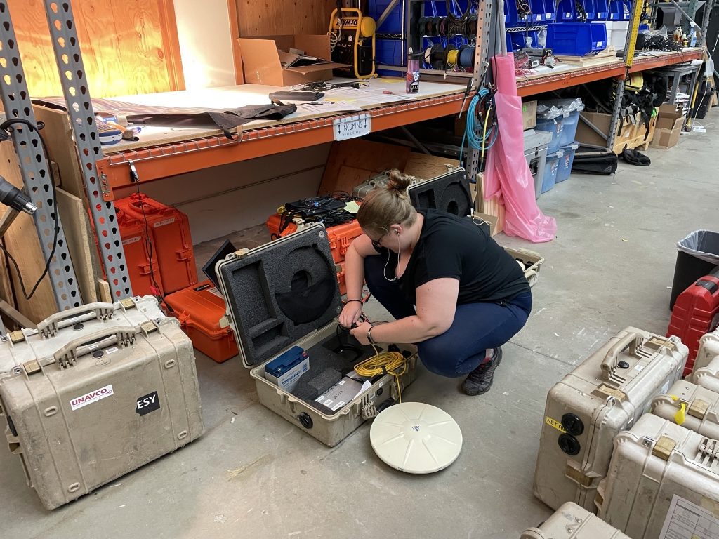 women kneeling to work on components in case