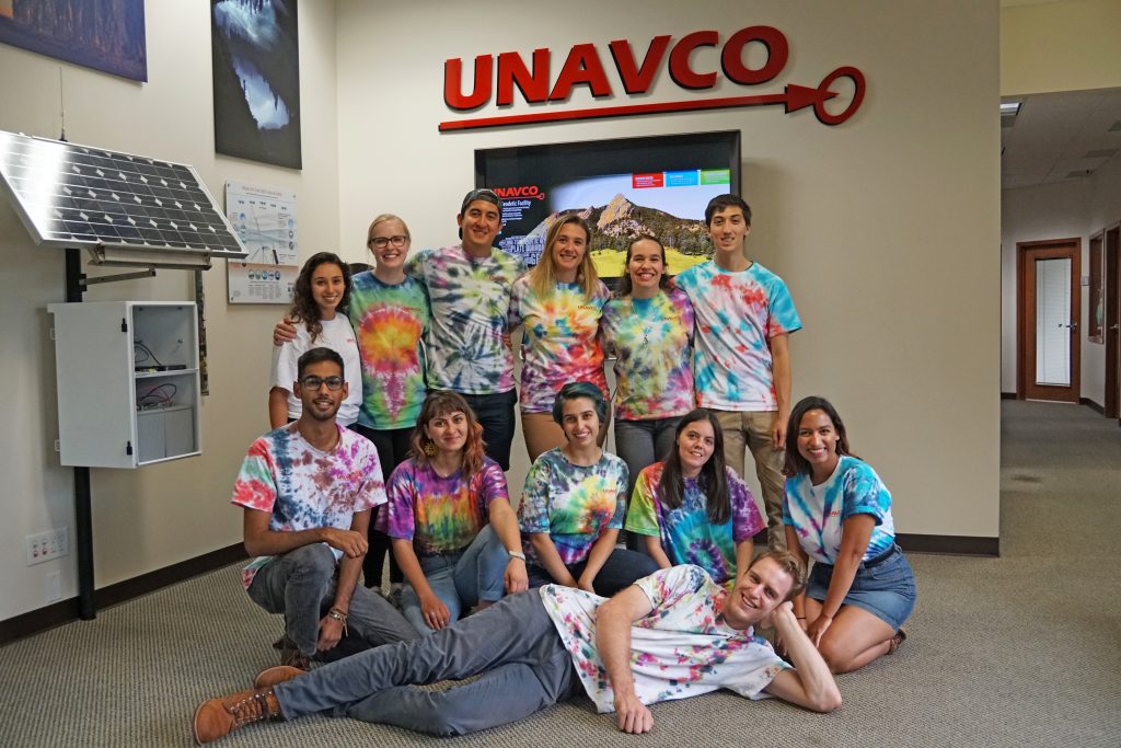 group of interns pose for photo in tie-dyed shirts