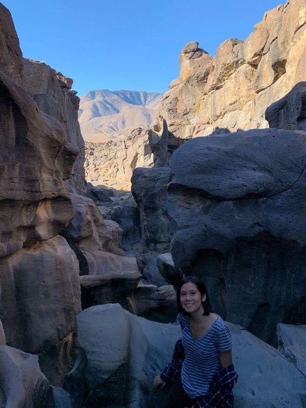 Elise Sits amongst eroded rocks in fossil falls, California