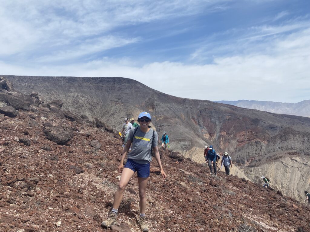 Elise and other members of her field team walk up the side of a mountain in rainbow canyon, death valley