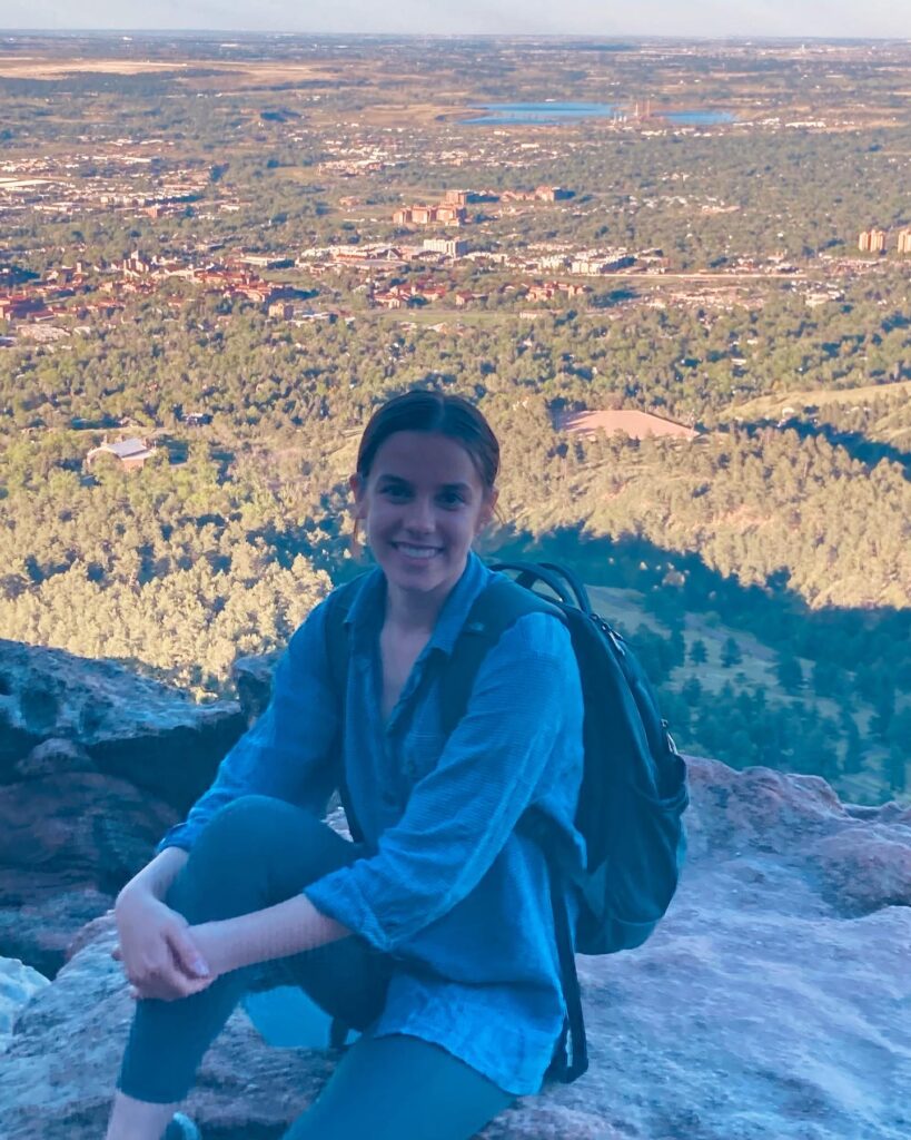 2022 RESESS Intern Halina Dingo sits on rock at the top of the Chautauqua Trail in Boulder, CO.