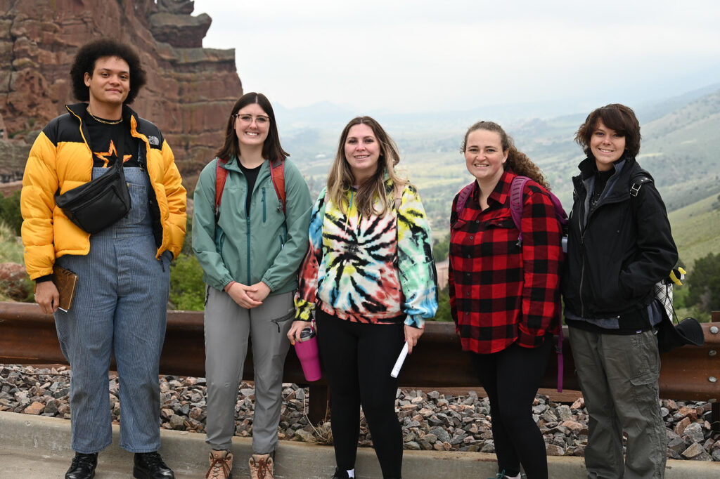 Kristen and her fellow Geo-Launchpad Interns standing against a guardrail at Red Rocks Amphitheatre in Colorado 