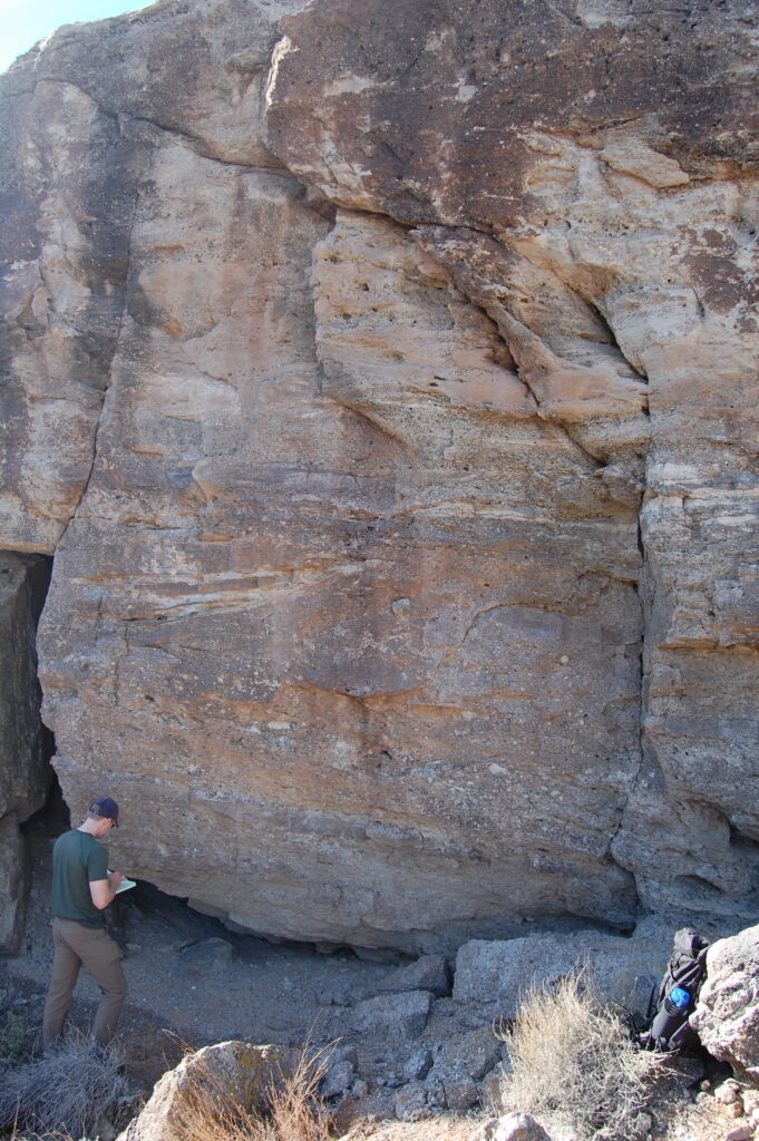 USIP Intern Cole Speed inspects an outcrop to examine ancient river channel deposits of the Cretaceous-age Cedar Mountain Formation, eastern Utah.