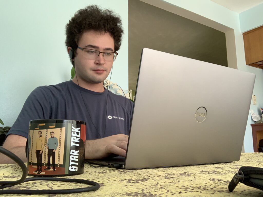 USIP Intern Zach Courter working on his laptop.