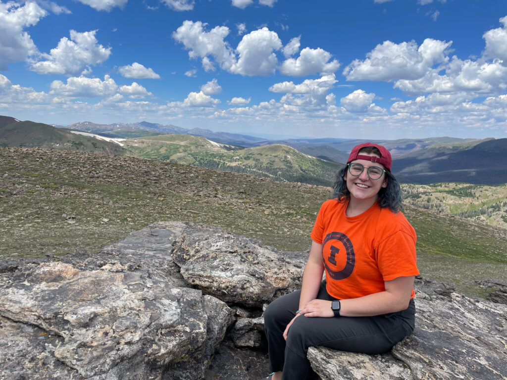 RESESS intern Addison Curtis sits on a rock overlooking rolling mountains at the Rocky Mountain National Park field trip.