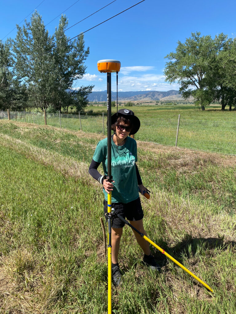 Geo-LaunchPad intern Taryn Roby stands with a portal GPS monument/antenna.