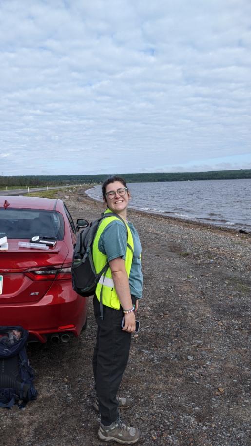 RESESS intern Addison Curtis smiling with a reflective vest in preparation to do field work in the Upper Peninsula of Michigan.