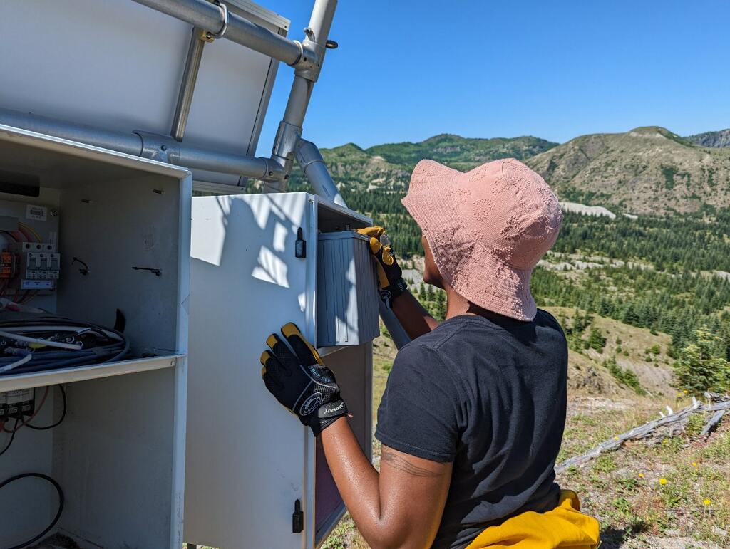 USIP Intern Kayla Byrd touching a battery inside an enclosure on the Mount St. Helens campaign trip.